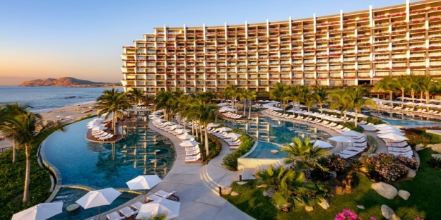 A pool with lounge chairs and a large building AI-generated content may be incorrect.